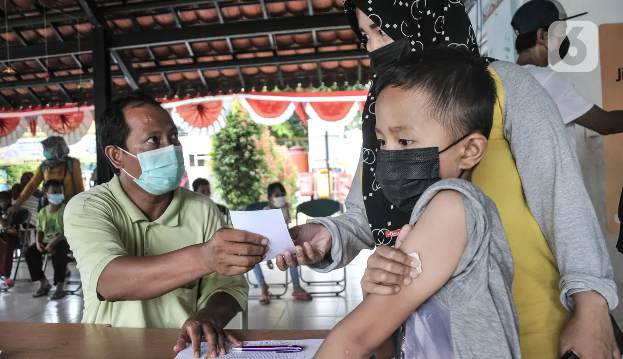 Petugas memberikan vitamin kepada anak usai mengikuti vaksin DT di RPTRA Citra Permata, Jakarta, Selasa (28/9/2021). Kegiatan rutin tahunan tersebut bertujuan memberikan kekebalan tubuh pada anak sekolah terhadap penyakit DT dengan kuota 150 anak per hari (merdeka.com/Iqbal S Nugroho)