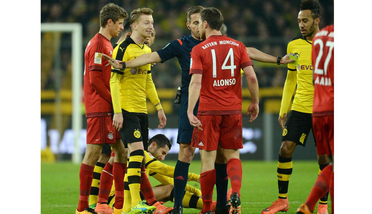 Pemain Munchen, Xabi Alonso  memprotes kartu kuning yaang diterimanya pada lanjutan Bundesliga 2015-2016 di Stadion Signal Iduna Park ,Dortmund, Minggu (5/3/2016) dini hari WIB. (EPA/Bernd Thissen)