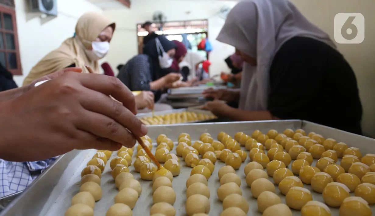 Pekerja menyelesaikan pembuatan kue kering lebaran di industri rumahan Risa Resa Cookies, Ciganjur, Jakarta, Senin (18/03/2023). (merdeka.com/Arie Basuki)
