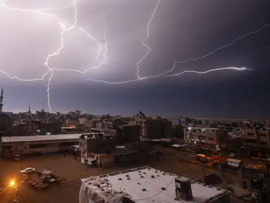 Kilatan petir terlihat saat hujan lebat di atas kota Rafah di Jalur Gaza selatan, Palestina, Kamis (16/1/2020). (AFP/Said Khatib)