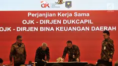 Mendagri Tjahjo Kumolo (kanan) didampingi Ketua Dewan Komisioner OJK Wimboh Santoso saat menyaksikan Dirjen Dukcapil dan Dirjen Bina Keuangan Daerah melakukan penandatanganan Nota Kesepahaman di Jakarta, Selasa (19/2). (Merdeka.com/Iqbal Nugroho)