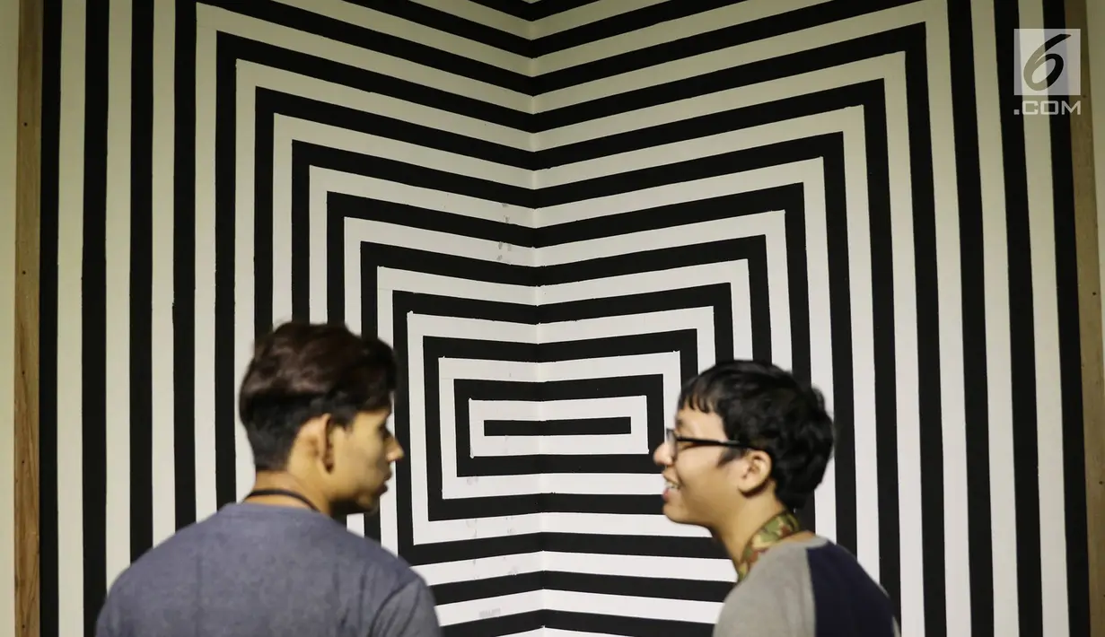 Pengunjung berbincang di depan karya yang dipajang dalam pameran bersama bertajuk 'Mutual Unknown' di Galeri Nasional, Jakarta, Sabtu (3/6). Pameran ini mengajak pengunjung untuk berinteraksi dengan 9 pameris. (Liputan6.com/Immanuel Antonius)