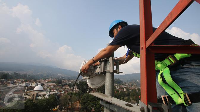 Teknisi XL melakukan perawatan atas perangkat BTS 4G di atas menara di kawasan Lembang, Bandung, (2/11/2015). Proses refarming atau penataan ulang frekuensi 1800Mhz telah selesai untuk wilayah Kota Bandung dan sekitarnya. (Liputan6.com/Yudha Gunawan)