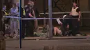 Sejumlah orang yang terluka mendapat tindakan dari tim medis setelah serangan teror di dekat London Bridge, Inggris, Minggu (4/6). Teror terjadi ketika sebuah mobil van menghantam para pejalan kaki yang berada di kawasan itu. (Federica De Caria/PA via AP)