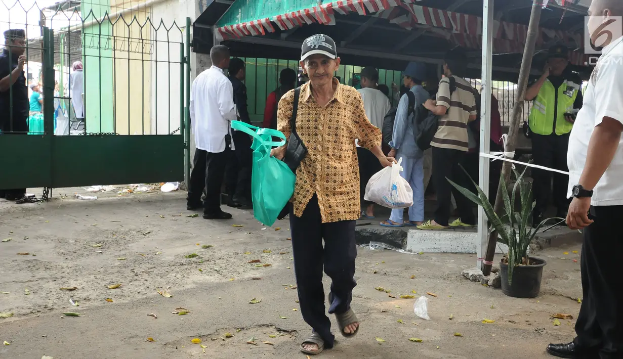 Warga berjalan usai pembagian daging kurban di sekitar Masjid Al Azhar, Jakarta, Jumat (1/9). Masjid Al Azhar Jakarta memotong dan mendistribusikan ratusan hewan kurban pada Hari Raya Idul Adha 1438 H. (Liputan6.com/Helmi Fithriansyah)