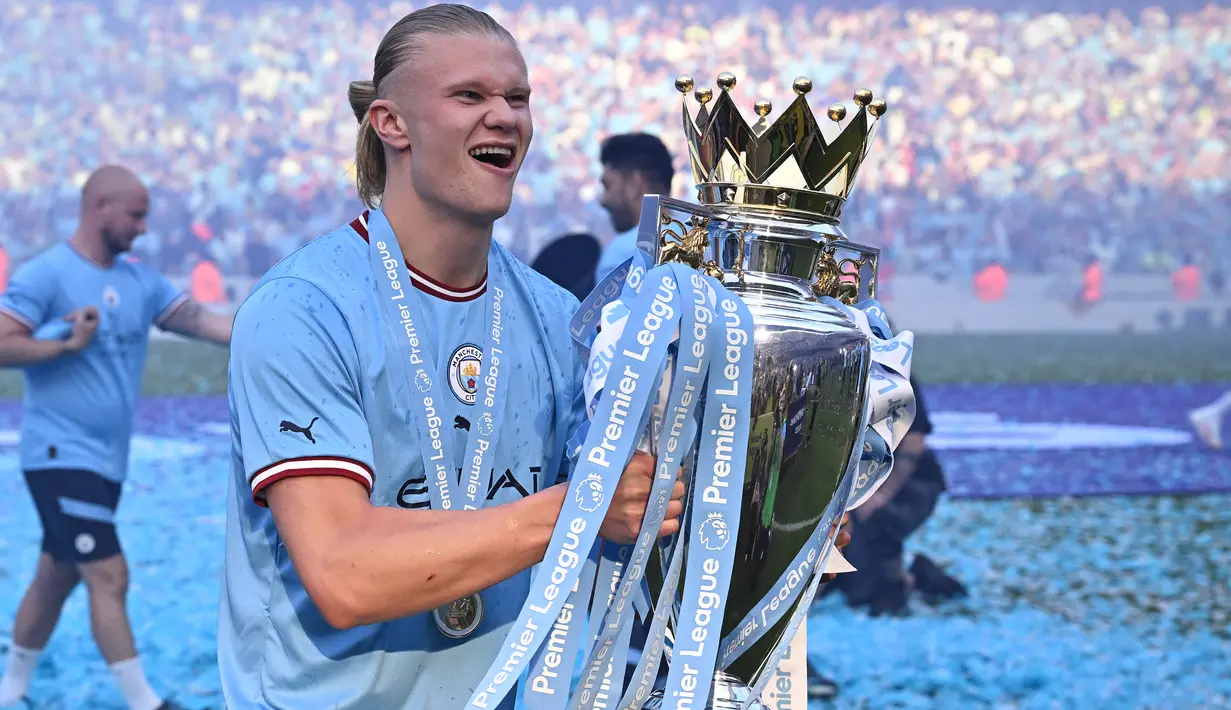 Selebrasi striker Manchester City, Erling Haaland dengan trofi juara Liga Inggris 2022/2023 setelah laga menghadapi Chelsea di Etihad Stadium, Manchester (21/5/2023). Erling Haaland menjadi alumnus RB Salzburg terbaru yang meraih trofi Liga Inggris bersama Manchester City pada musim 2022/2023. Sebelum diboyong Man City dari Borussia Dortmund pada awal musim 2022/2023, Erling Haaland pernah membela RB Salzburg pada musim 2018/2019 dan 2019/2020. (AFP/Oli Scarff)
