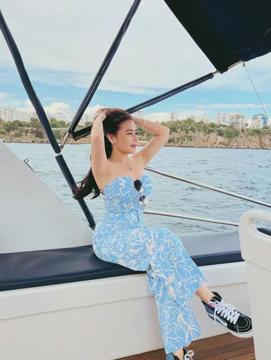 Ia mengenakan strapless top yang dipadukan dengan celana bermotif senada. Outfit yang sama juga ia kenakan saat menaiki kapal menyusuri laut di wilayah Antalya.
