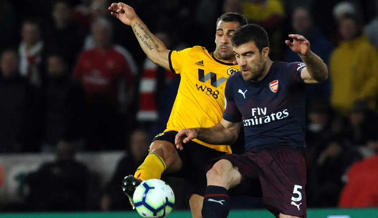 Bek Arsenal, Sokratis Papastathopoulos berebut bola dengan pemain Wolverhampton Wanderers, Jonny Otto pada laga lanjutan Liga Inggris 2018-2019 di Stadion Molineux, Rabu (24/4). Arsenal harus tumbang dengan skor 1-3 kala bertandang ke markas Wolverhampton Wanderers. (AP Photo/Rui Vieira)