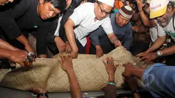 Keluarga dan sahabat saat akan memasukkan jenazah Mpok Nori ke dalam liang lahat di TPU Pondok Ranggon, Jakarta Timur, Jumat (3/4/2015). (Liputan6.com/Helmi Afandi)