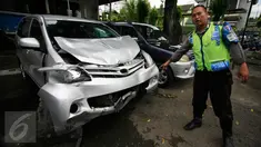 Petugas menunjukan mobil yang ringsek akibat kecelakaan lalulintas di simpang empat Tugu Pal Putih Yogyakarta, Senin (30/5). Kecelakaan yang terjadi pada minggu (29/5) pagi ini menewaskan 2 orang. (Boy Harjanto)