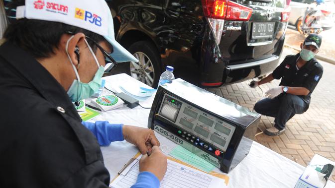 Petugas mengukur kadar emisi kendaraan saat dilakukan uji emisi di Taman Kota 1 BSD, Tangerang Selatan, Rabu (3/10). Dinas Lingkungan Hidup (DLH) Kota Tangerang Selatan menggelar uji emisi guna menekan angka polusi kendaraan. (Merdeka.com/Arie Basuki)
