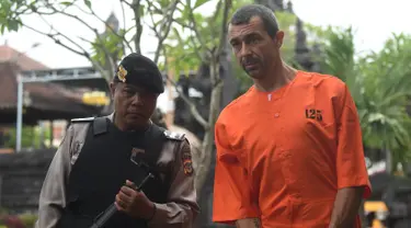 Warga negara Prancis Samuel Pierre Danguny dikawal oleh polisi sebelum konferensi pers di kantor polisi di Denpasar, Bali (18/3). Danguny ditangkap pada 15 Maret dengan kepemilikan 33 gram ganja dan 2 paket Hasis 16 gram. (AFP Photo/Sonny Tumbelaka)