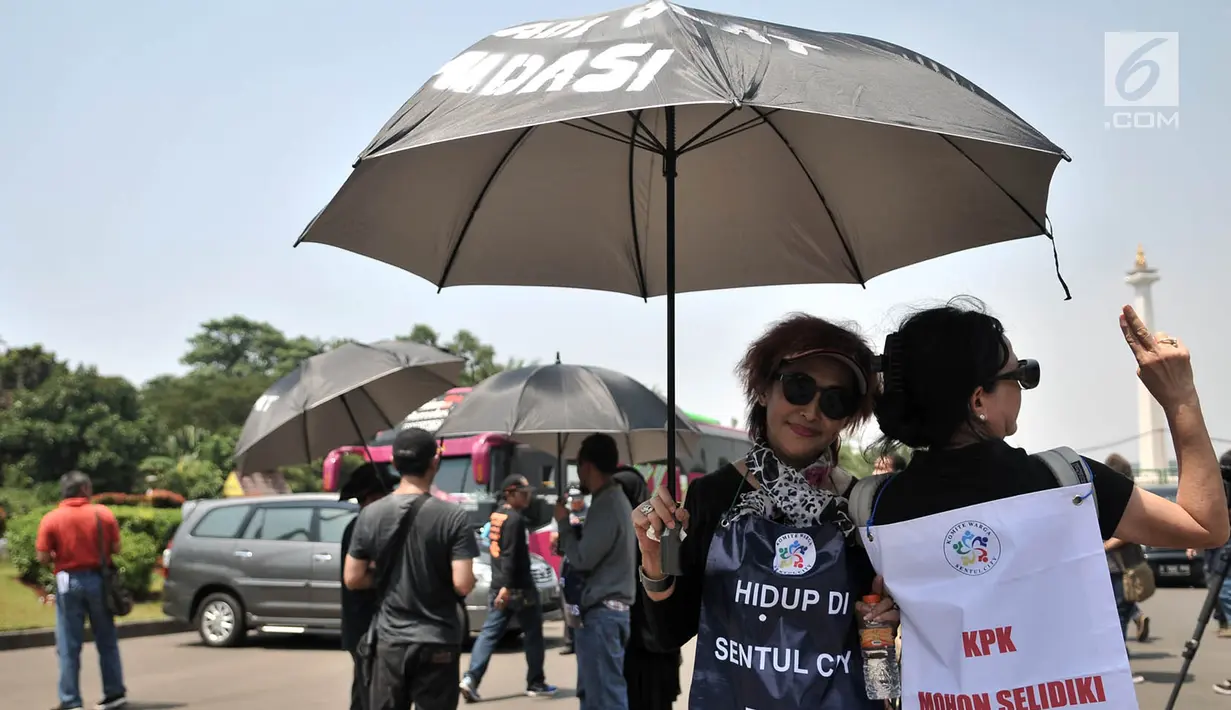Aksi massa dari Komite Warga Sentul City mengenakan payung hitam di depan Istana Negara, Senin (30/4). Mereka meminta proses hukum terhadap pengembang perumahan Sentul City karena diduga terjadi penguasaan pengelolaan air. (Merdeka.com/Iqbal Nugroho)