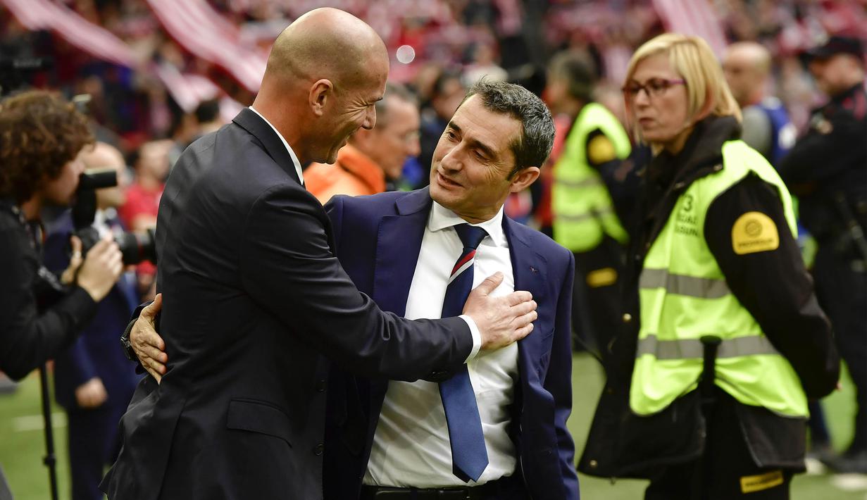 Pelatih Athletic, Ernesto Valverde, berbincang dengan pelatih Real Madrid, Zinedine Zidane, sebelum laga La Liga di Bilbao, Sabtu (18/3/2017). Valverde ditunjuk sebagai pelatih Barcelona menggantikan Luis Enrique. (AP/Alvaro Barrientos)