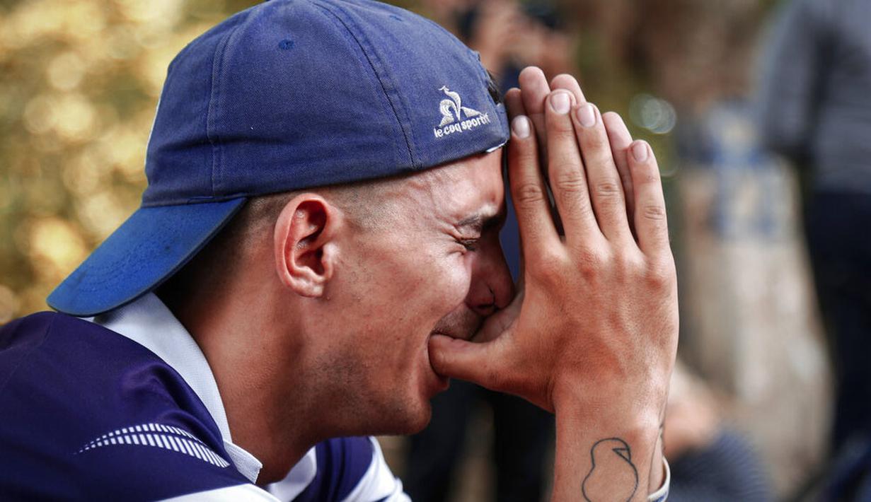 Seorang fans menangis usai meninggalnya Diego Maradona di La Plata, Argentina, Rabu (25/11/2020). legenda sepak bola Argentina itu meninggal dunia pada usia 60 tahun setelah menderita serangan jantung. (AP/Maria Paula Avila)