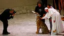 Paus Francis saat membelai seekor harimau di tengah acara sirkus jalanan yang digelar di Aula Paulus VI,Vatikan (16/6). Di sela-sela pertunjukan sirkus, Paus Francis diberi kesempatan memegang harimau. (REUTERS/Tony Gentile)