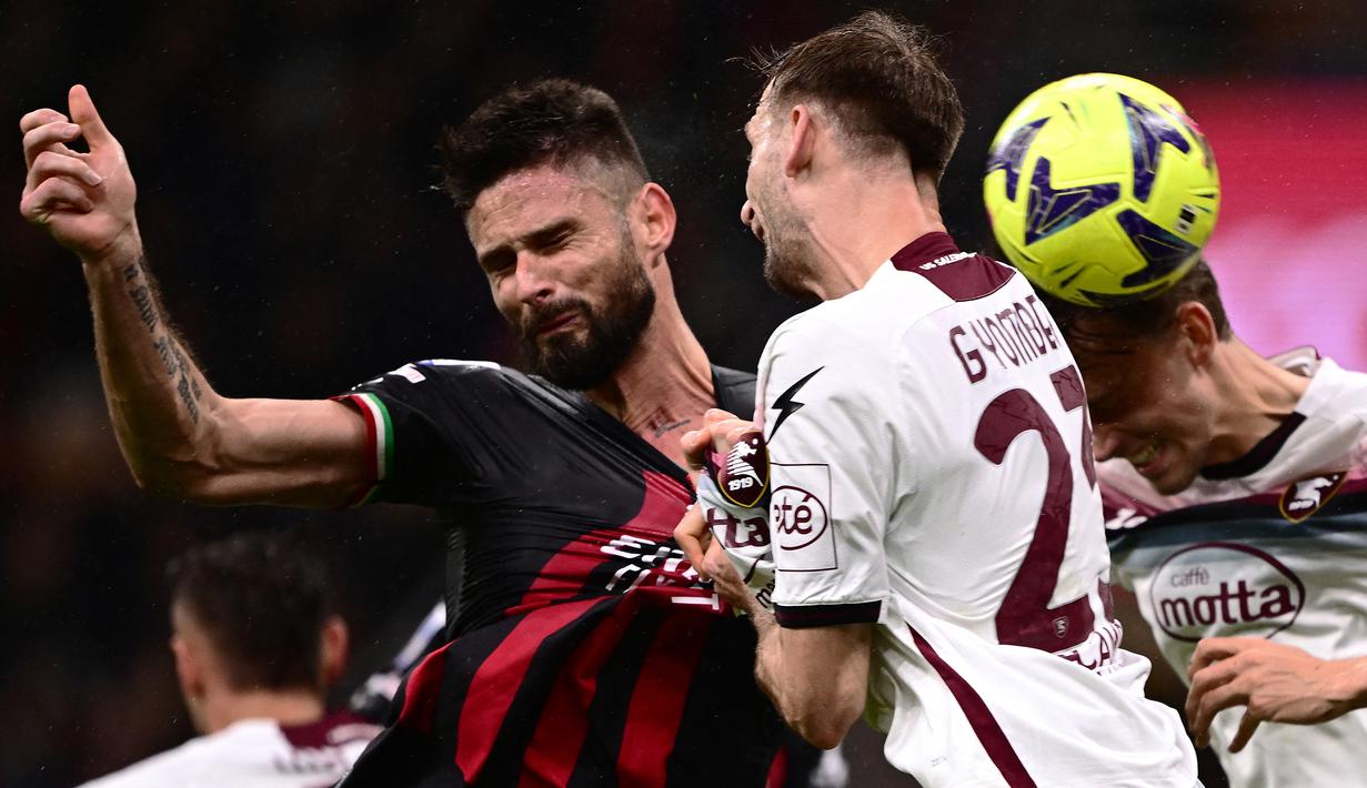 Striker AC Milan, Olivier Giroud (kiri) melepaskan sundulan yang menghasilkan gol ke gawang Salernitana pada laga pekan ke-26 Liga Italia 2022/2023 di San Siro Stadium, Milan, Selasa (14/3/2023) dini hari WIB. (AFP/Marco Bertorello)