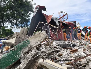 Tim penyelamat mencari tiga orang yang dilaporkan hilang di bawah reruntuhan bangunan yang runtuh di Kota Bogo, Filipina pada 1 Oktober 2025. (TED ALJIBE/AFP)