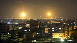 Api dari rudal militer Israel menerangi langit kota Gaza. Militer Israel kembali melakukan serangan udara ke kota Gaza, Palestina, (12/7/2014). (AFP PHOTO/Mahmud Hams)