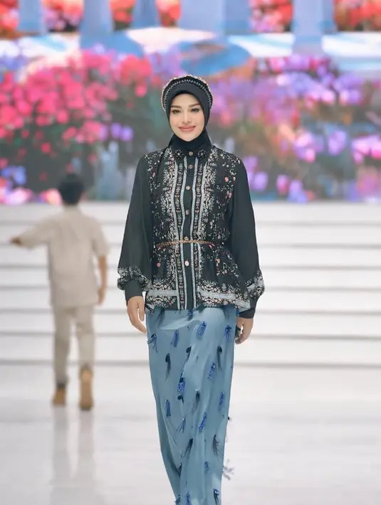 <p>Aurel Hermansyah tampil dengan brand Shi by Shireen Sungkar. Ia mengenakan atasan kemeja hitam bercorak bunga lengan panjang pump dipadukan kerudung warna senada serta bondu beads. Ia memilih skirt panjang baby blue dengan aksen bulu-bulu. [@aurelie.hermansyah]</p>