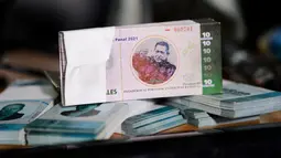 Sejumlah uang lokal baru yang berada di Caracas, Venezuela (15/12). Mata uang ini  bisa ditukarkan secara lokal untuk transaksi makanan pokok seperti gula, beras dan roti yang diproduksi di lingkungan itu sendiri. (AFP Photo/Federico Parra)