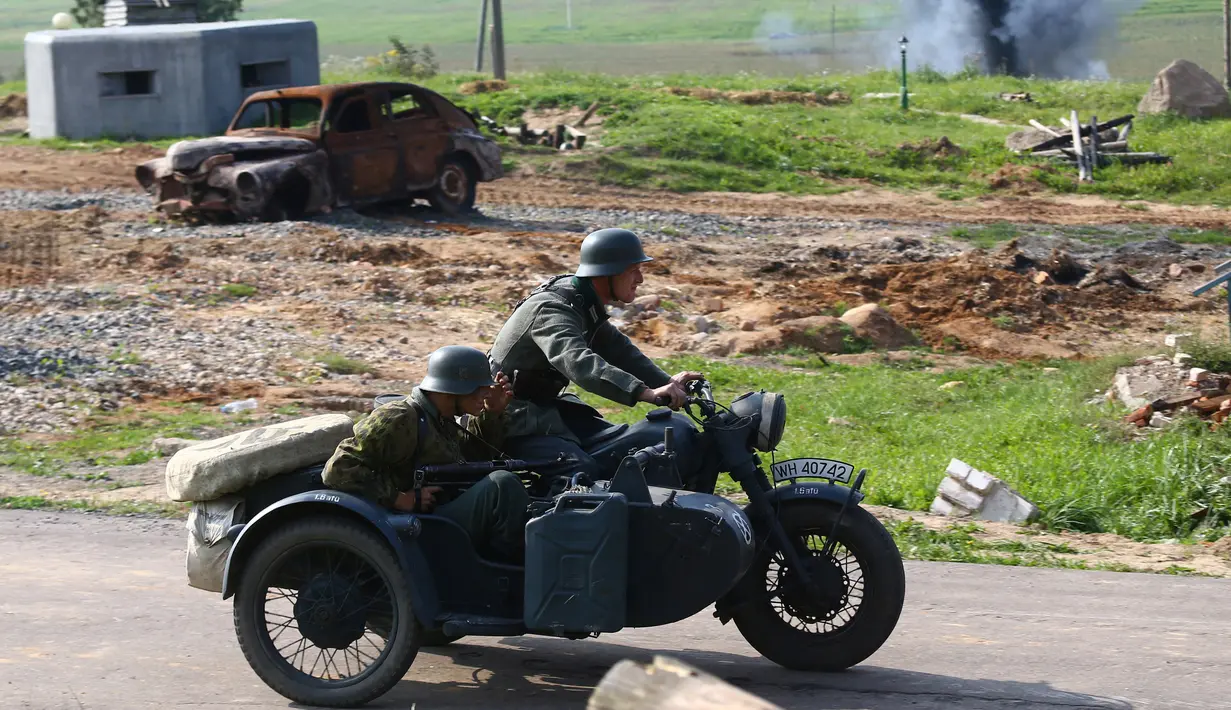 Adegan aktor sedang mengendarai motor lengkap dengan atribut tentara saat memainkan rekonstruksi pertempuran Perang Dunia II, di Memorial "Stalin Line", dekat Desa Goroshki, Belarusia, (10/9). (Reuters/Vasily Fedosenko)