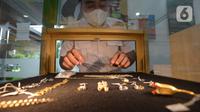 Petugas pegadaian memperlihatkan lelang emas perhiasan di kantor pusat Pegadaian, Jakarta, Selasa (20/4/2021). PT Pegadaian (Persero) terus berupaya memberikan pelayanan kepada masyarakat Indonesia. (merdeka.com/Imam Buhori)
