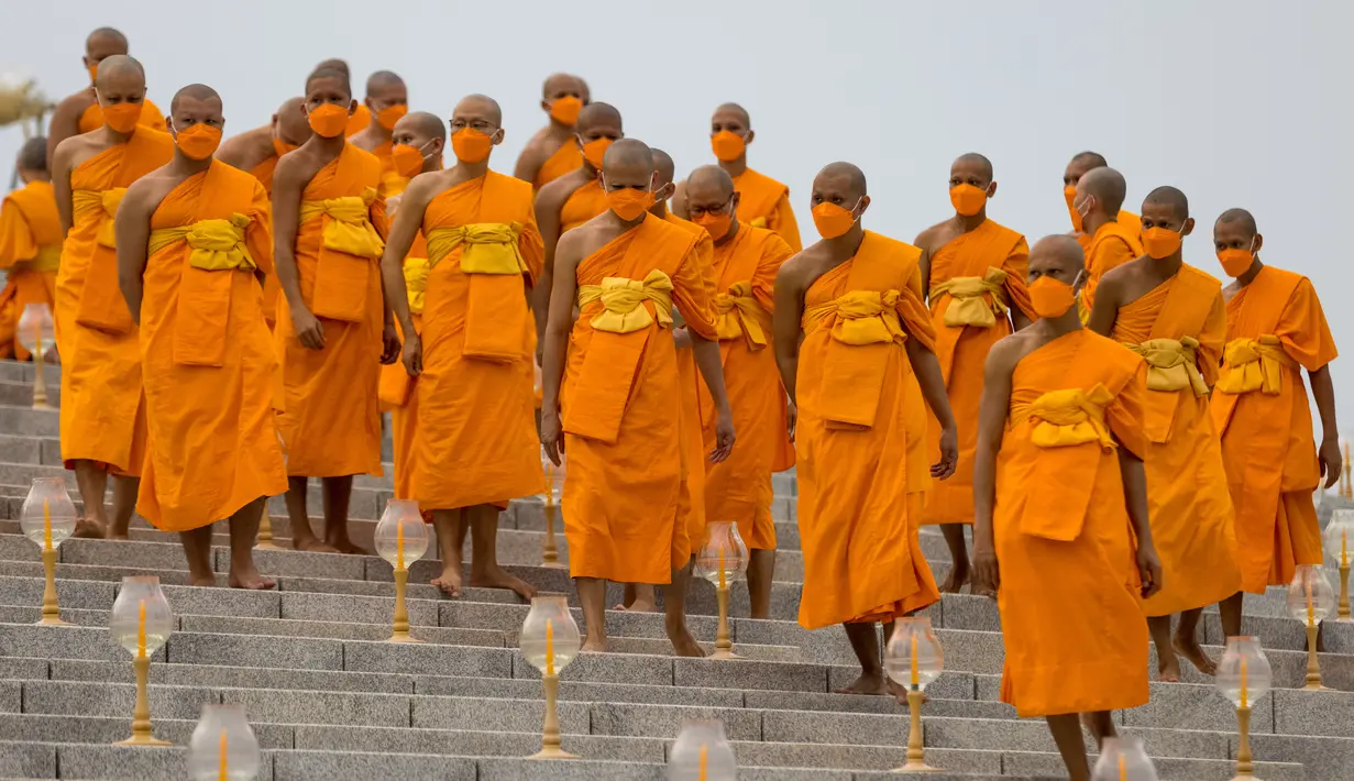 Biksu Buddha menghadiri perayaan Makha Bucha di kuil Wat Dhammakaya di provinsi Pathum Thani, utara Bangkok (16/2/2022). Makha Bucha merupakan salah satu hari raya terpenting bagi para penganut agama Buddha. (AFP/Jack Taylor)