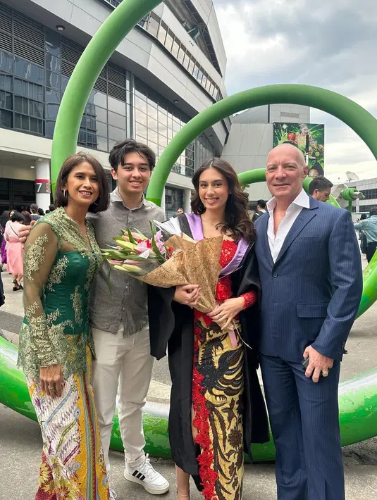 Kebaya model kerah boatneck tersebut dipadukan rok batik warna coklat dengan detail brokat warna merah senada dengan kebayanya dan high slit yang mengekspos kaki jenjangnya. [@kiaramckenna]