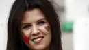 Suporter Portugal ini mengecat wajahnya dengan gambar bendera Portugal saat mendukung timnya melawan Islandia di Stadion Geoffroy-Guichard, Saint-Etienne, (14/10/2016). (AFP/Odd Andersen)