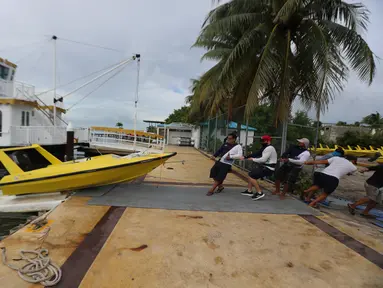 Sejumlah orang memindahkan sebuah perahu saat Badai Delta mendekati Puerto Morelos, Negara Bagian Quintana Roo, Meksiko, 6 Oktober 2020. Status Badai Delta naik menjadi topan tropis kategori 4 pada Selasa (6/10) pagi waktu setempat ketika bergerak menuju Mexican Caribbean. (Xinhua/Mauricio Collado)