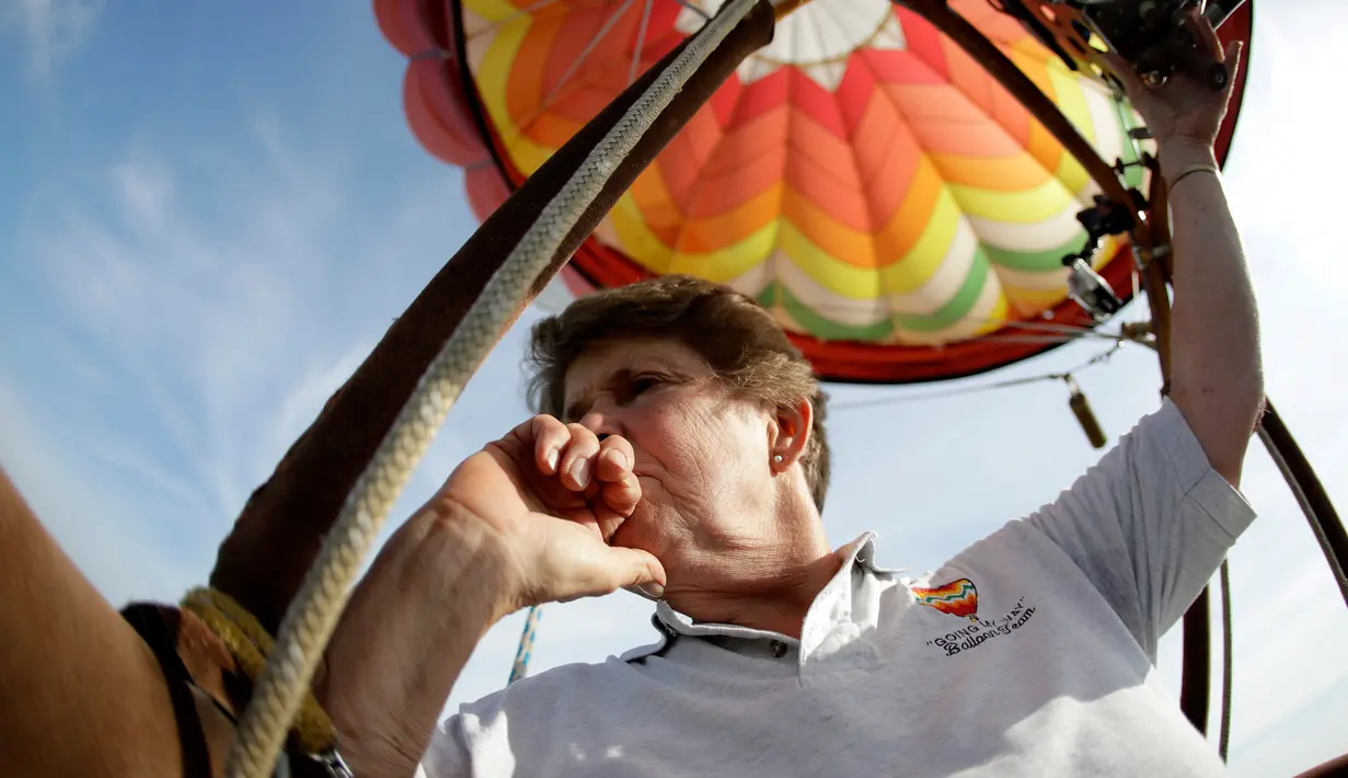 Peserta dari Parsippany, Mary Beth Young mengendarai balon udara panas yang terbang di atas Bandara Solberg saat Festival Balon QuickChek New Jersey di Kota Readington, New Jersey (28/7). (AP Photo/Julio Cortez)