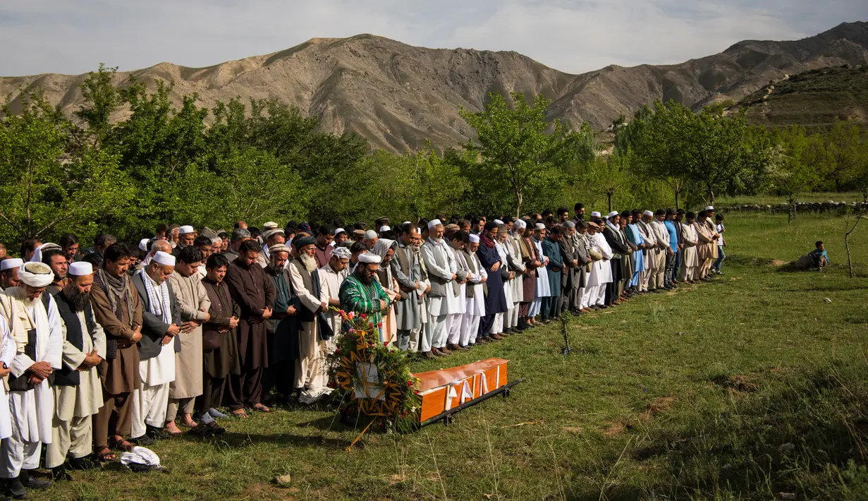Teman dan kerabat mensalatkan jenazah kepala fotografer Agence France Presse (AFP) Afghanistan Shah Marai Faizi di Gul Dara, Kabul (30/4). (Andrew Quilty / POOL / AFP)