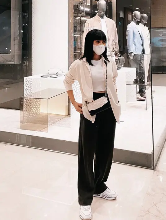 Cita Citata tampil kasula dengan tanktop putih sebagai inner, dan kemeja oversize sebagai outer. Dipadukan dengan loose pants hitam dan sepatu sneakersnya. Slingbag putih hitam menjadi penunjang penampilannya @cita_citata