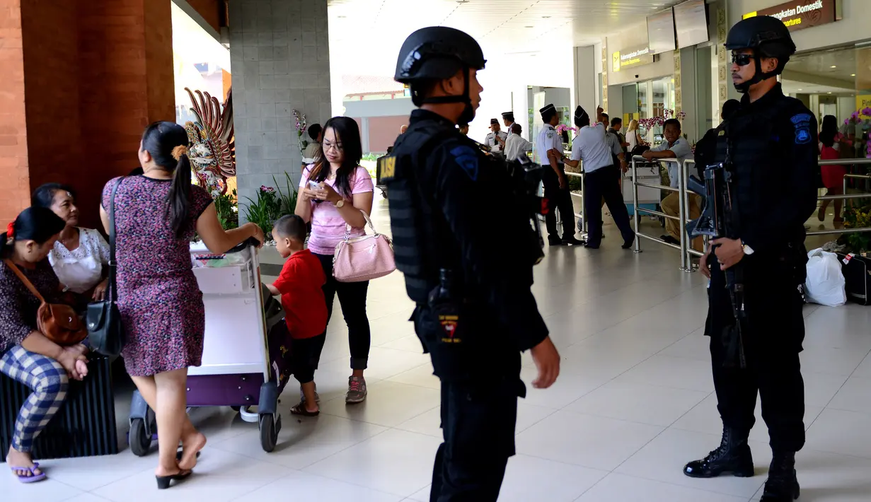 Dua anggota polisi melakukan pengamanan di Bandara Ngurah Rai, Denpasar, Bali, Jumat (15/1). Pasca peristiwa serangan di Sarinah, Jakarta, pengelola Bandara Internasional I Gusti Ngurah Rai, Bali perketat pengamanan. (AFP PHOTO/Sonny Tumbelaka)