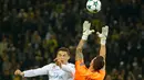 Kiper Borussia Dortmund, Roman Buerki menangkap bola yang ditendang pemain Real Madrid, Cristiano Ronaldo dalam lanjutan Liga Champions di Signal Iduna Park, Rabu (27/9). Dua gol Ronaldo mewarnai kemenangan Real Madrid 3-1. (AP/Michael Probst)