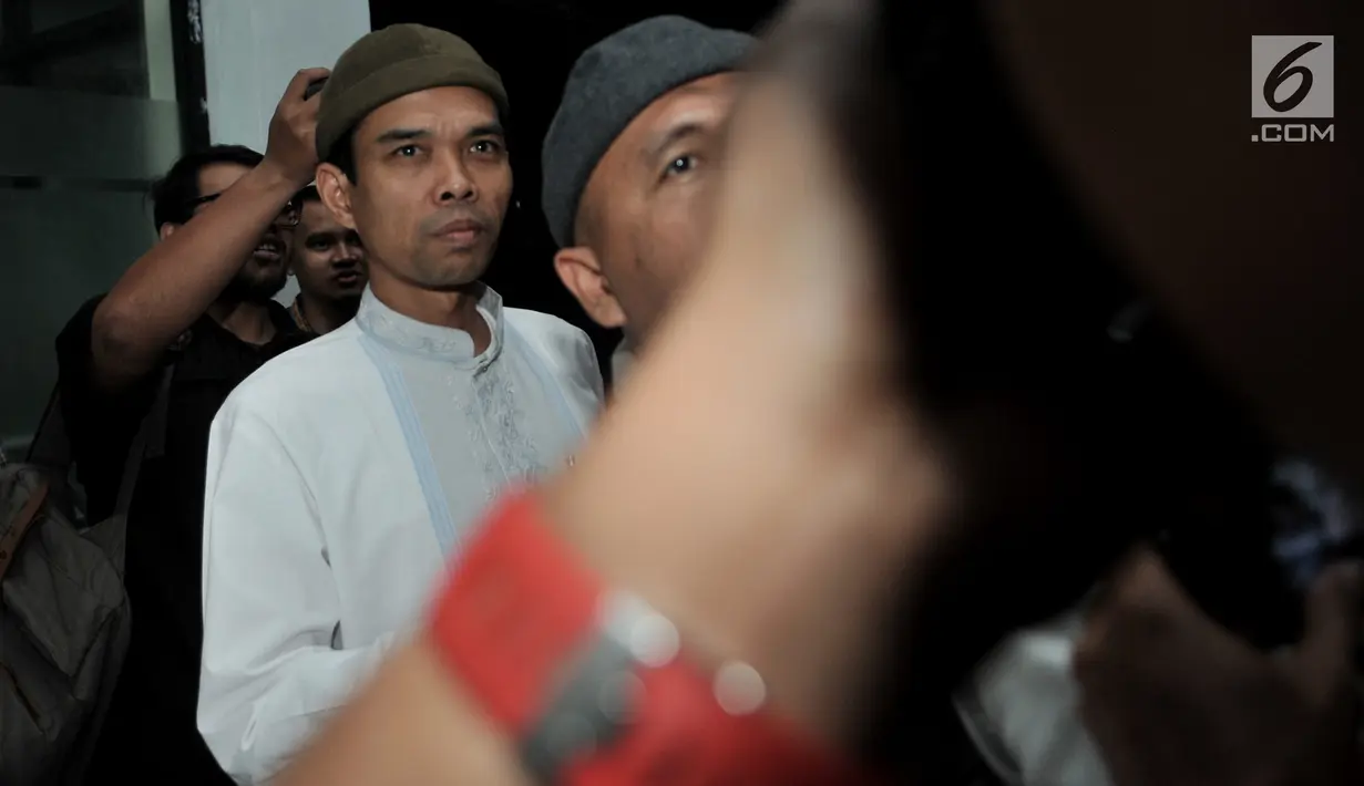 Ustaz Abdul Somad (UAS) berusaha menghindari kerumunan awak media setibanya di Kantor Majelis Ulama Indonesia (MUI), Jakarta, Rabu (21/8/2019). UAS memenuhi undangan MUI untuk menyampaikan klarifikasi mengenai video ceramahnya yang viral dan memicu polemik. (merdeka.com/Iqbal S Nugroho)