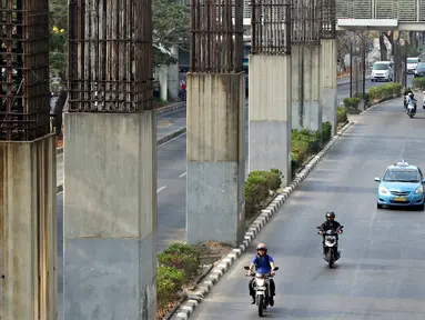 Tiang-tiang pancang penyangga monorel menjulang di sepanjang Jalan Rasuna Said, Jakarta, Jumat (30/10). Presiden Joko Widodo menyatakan seluruh tiang pancang bekas monorel akan difungsikan sebagai tiang penyangga rel LRT. (Liputan6.com/Immanuel Antonius)