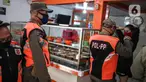 Petugas Satpol PP menertibkan warung makan yang melanggar aturan pembatasan sosial berskala besar (PSBB) di kebon kacang, Jakarta, Senin (1/6/2020). Pelanggaran berupa menerima pelanggan yang makan di warung ditertibkan oleh petugas untuk mencegah penyebaran COVID-19. (Liputan6.com/Faizal Fanani)