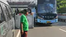 Bus pariwisata berjalan melewati mobil boks yang terbalik di KM 02 Tol Cawang arah Cililitan, Jakarta, Senin (30/5). Petugas tengah melakukan penyelamatan pengemudi dan membawa badan mobil bernomor polisi B 9385 HH itu (Liputan6.com/Yoppy Renato)