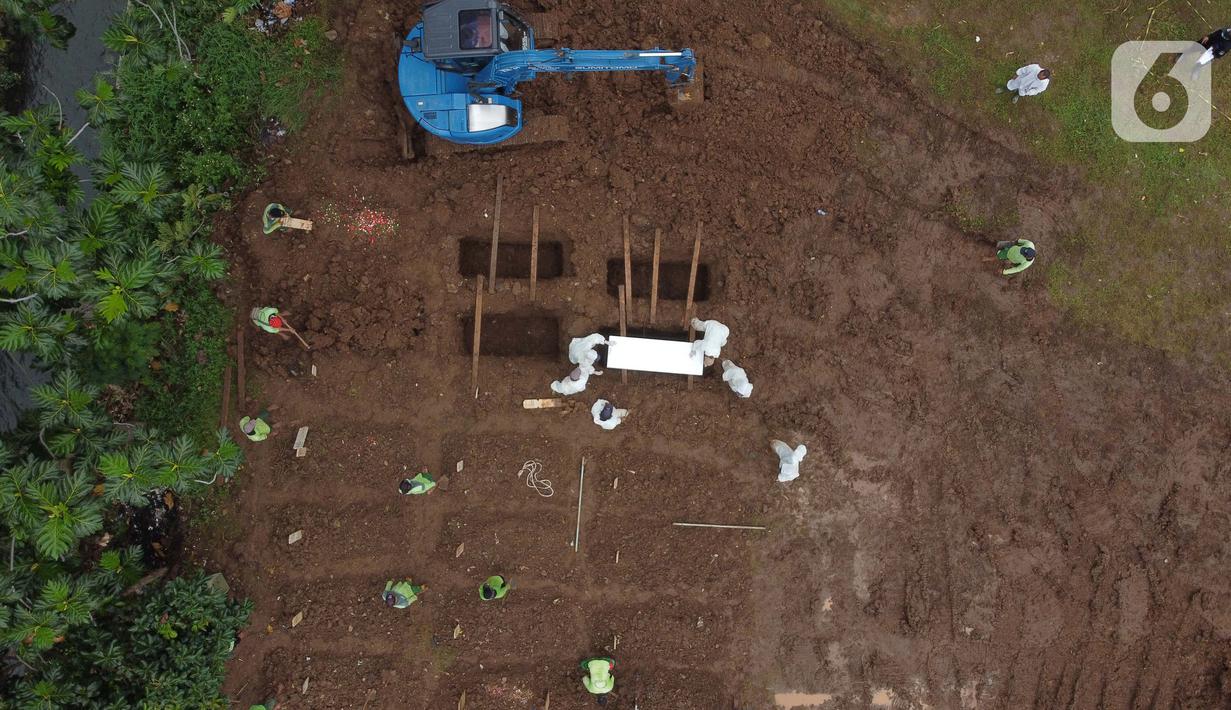 Foto udara pemakaman jenazah dengan protokol COVID-19 di TPU Srengseng Sawah, Jakarta, Kamis (21/1/2021). Sebagian lahan TPU Srengseng Sawah yang dijadikan pemakaman jenazah Covid-19 sejak Selasa (12/1) lalu, dengan kapasitas 564 petak makam kini nyaris penuh. (Liputan6.com/Helmi Fithriansyah)