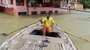 Warga menggunakan perahu sebagai sarana transportasi saat banjir bandang melanda wilayah Allahabad, India (26/8). (REUTERS/Jitendra Prakash)