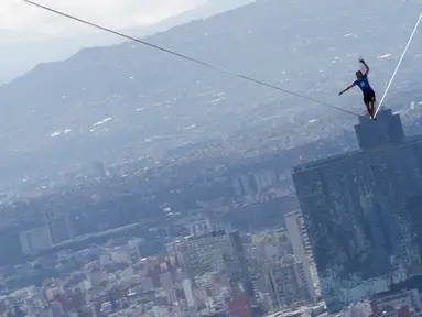 Alexander Schultz, asal Jerman mulai berjalan di antara dua gedung tertinggi Mexico City menggunakan tali pada ketinggian 246 meter di Meksiko, 4 Desember 2016. Schultz butuh lima kali usaha menaklukkan tali sepanjang 217 meter itu. (REUTERS/Stringer)