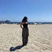 Berada di pantai Amerika, Cinta tampil dengan kemben hitam dipadukan celana cargo hijaunya. [@cintakuya]