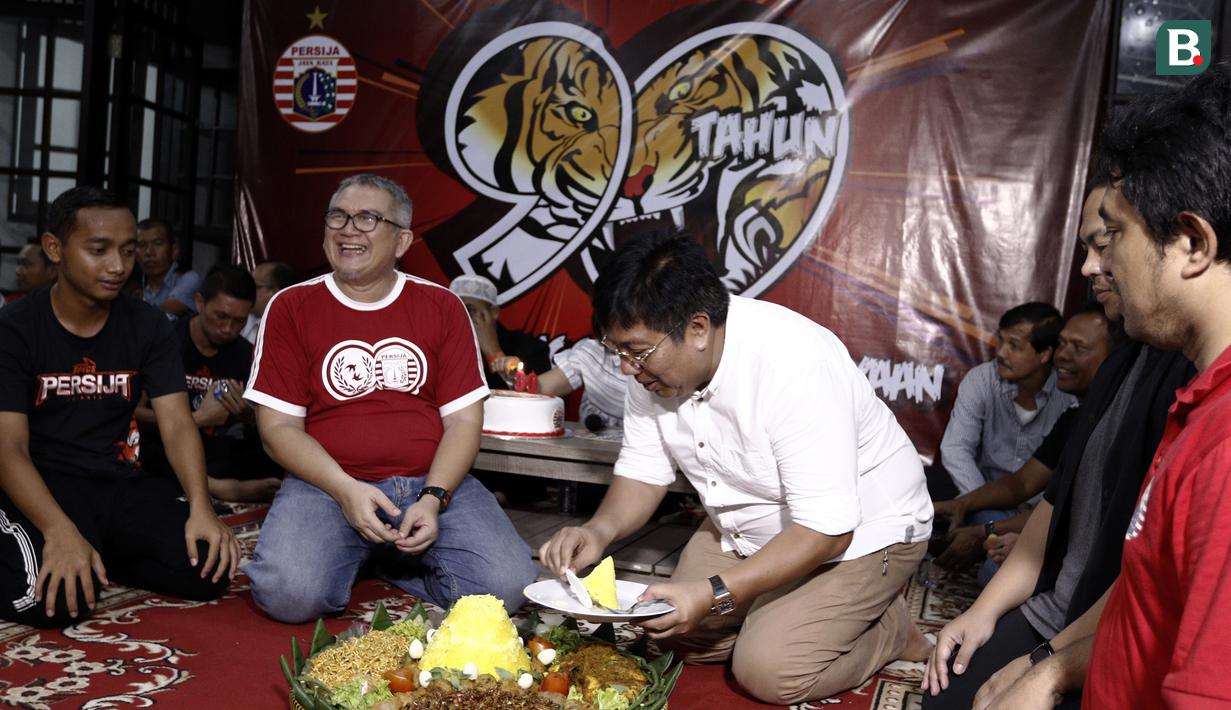 Direktur Utama Persija Jakarta, Gede Widiade, didampingi Ketua Umum Jakmania, Ferry Indrasjarief, memotong tumpeng saat acara syukuran di Kantor Persija, Jakarta. Acara ini merupakan peringatan hari jadi Persija ke-90. (Bola.com/Yoppy Renato)