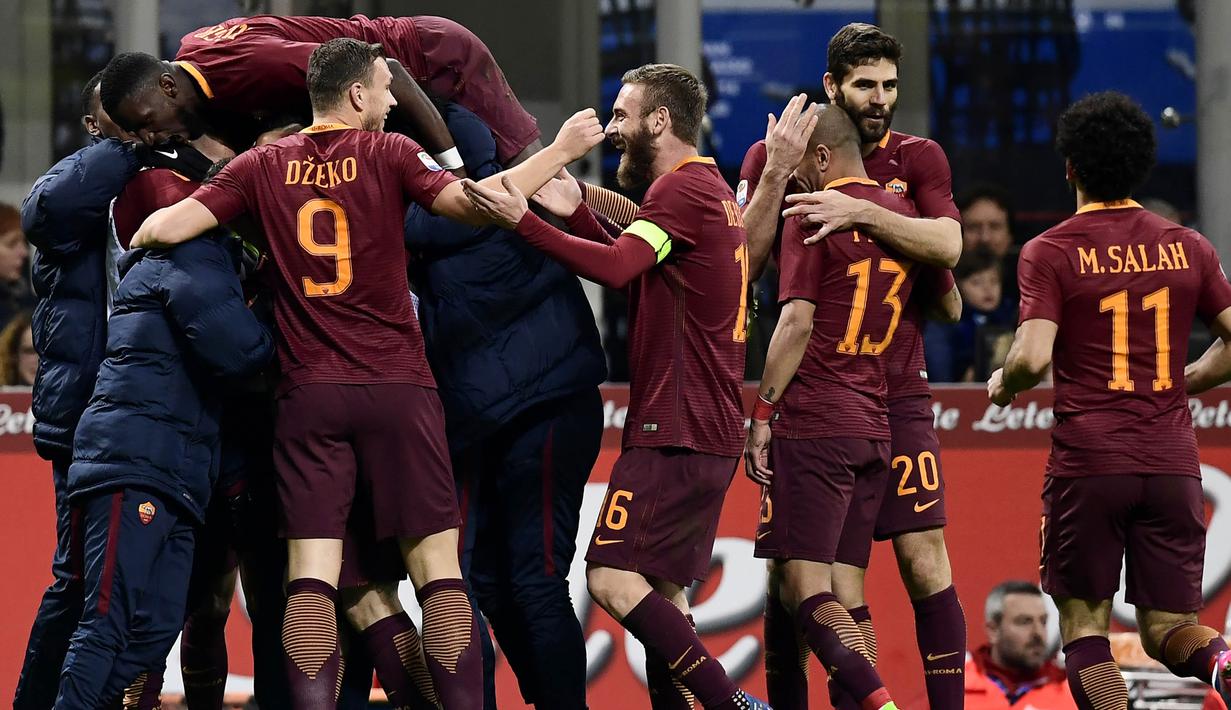 Para pemain AS Roma merayakan keberhasilan menaklukkan Inter Milan. Kemenangan ini membuat Roma kian kokoh di peringkat kedua Liga Italia, sementara Inter tertahan di posisi keenam. (AFP/Miguel Medina)