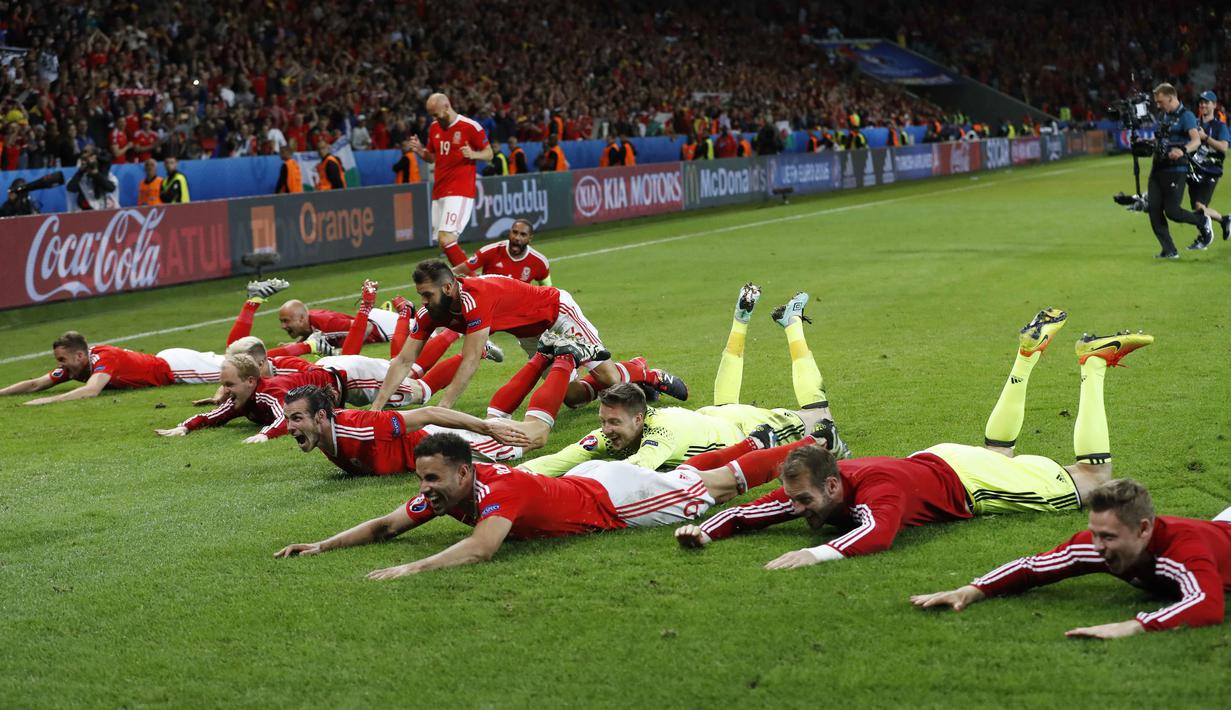Para pemain Wales merayakan kemenangan atas Belgia dengan berselancar diatas rumput pada laga perempat final Piala Eropa 2016 di Stade Pierre-Mauroy, Lille, Prancis, Sabtu (2/7/2016) dini hari WIB. (REUTERS/Carl Recine)