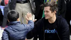 Duta UNICEF, Aktor Orlando Bloom melakukan tos dengan seorang anak  saat mengunjungi kamp transit migran di Gevgelija, Makedonia, 29 September 2015. (REUTERS/Ognen Teofilovski)
