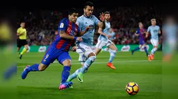 Suarez (kiri) berusaha melewati hadangan pemain Celta Vigo dalam lanjutan Liga Spanyol pekan ke-26 di Stadion Camp Nou, Minggu (5/3). Barca pesta gol ke gawang  Celta Vigo dengan skor 5-0. (AP PHOTO)