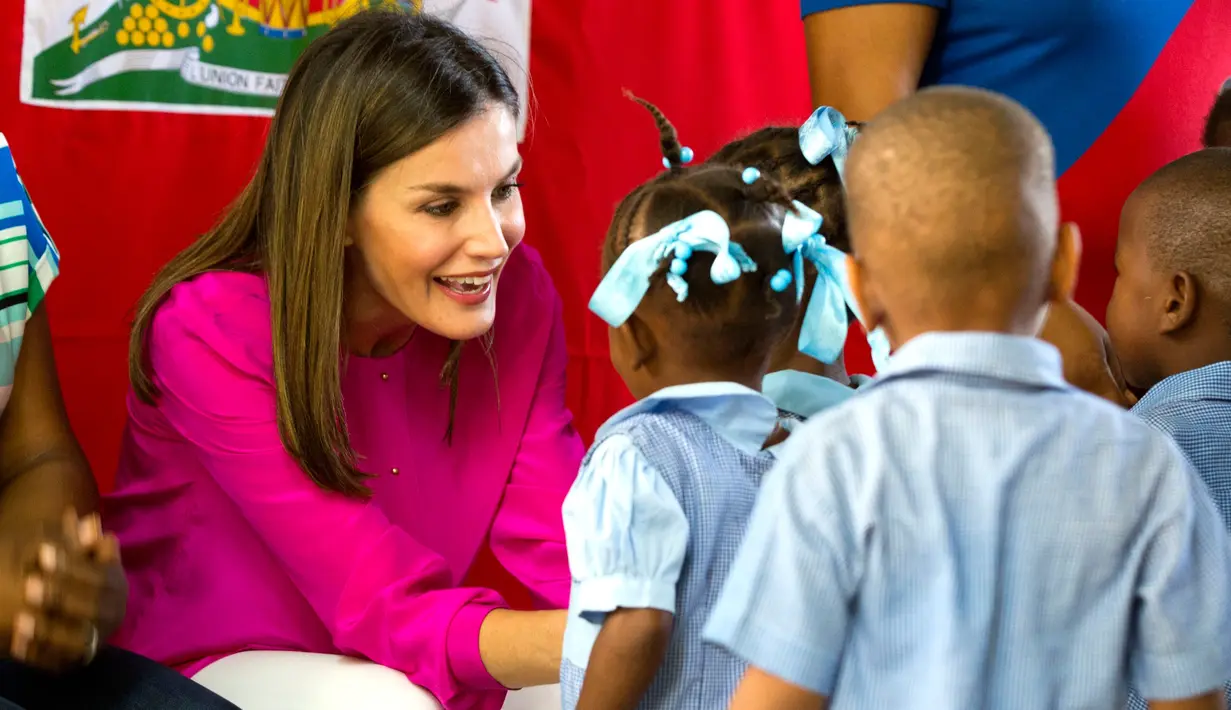 Ratu Spanyol Letizia berbincang dengan para siswa saat upacara penyambutannya di sebuah sekolah daerah kumuh Soleil, Haiti, 23 Mei 2018. Ini merupakan kunjungan pertama Ratu Letizia ke negara termiskin di benua Amerika tersebut. (AP/Dieu Nalio Chery)